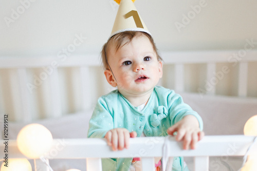 Portrait of cute baby girl wearing birthday hat, one year old birthday celebration .