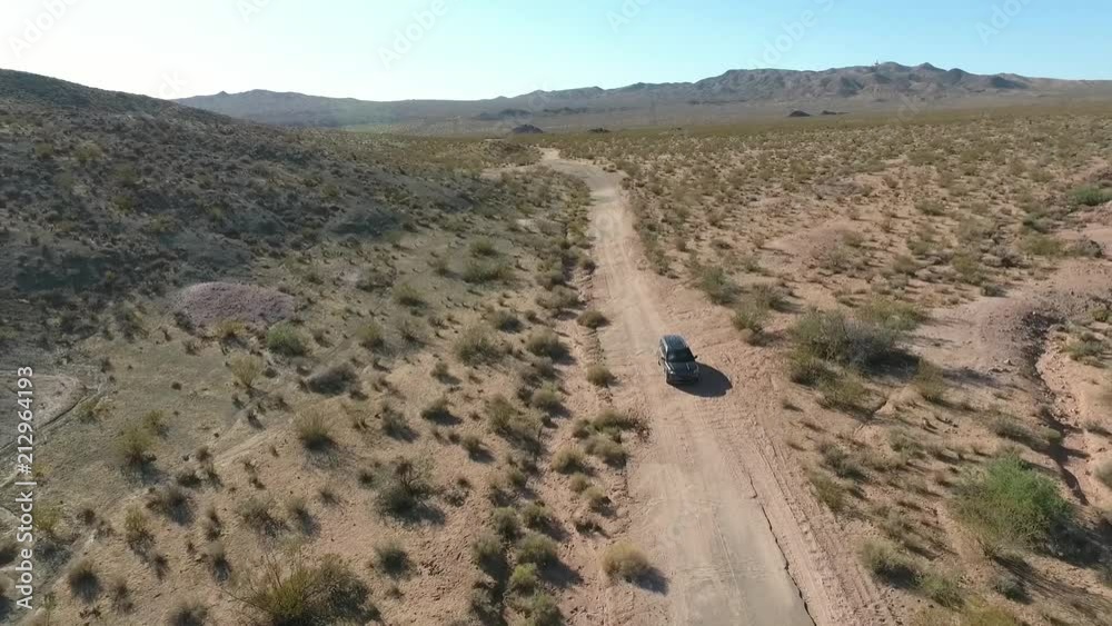 Flight over long highway at monument valley in Utah - Drone Aerial over cars in Arizona. Top view drone footage flying over dry and beige desert, drought resulted landscape, global warming threat Flight over long highway at monument valley in Utah - Drone Aerial over cars in Arizona. Top view drone footage flying over dry and beige desert, drought resulted landscape, global warming threat