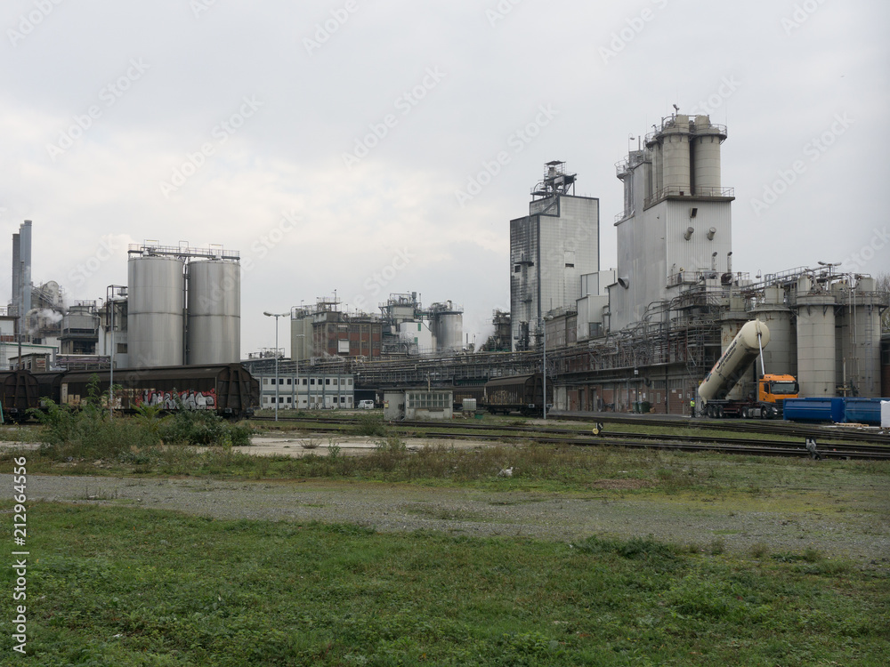 Large chemical factory in gray in cloudy weather with railway station Large chemical factory in gray in cloudy weather with railway station