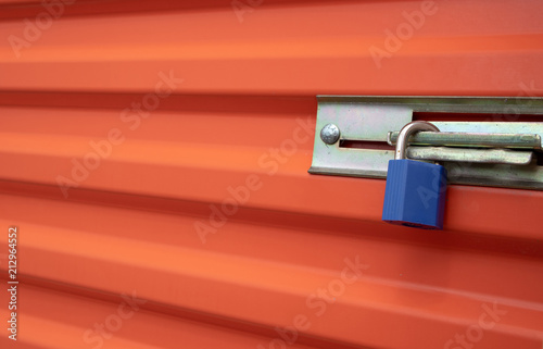 Obraz na plátne Blue plastic lock on an orange self storage unit door.
