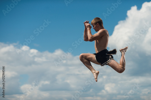 Man flying kick in sky background. Martial arts composition