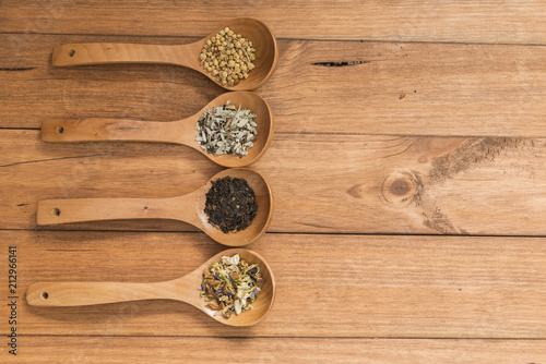 Wooden spoons with different herbs for infusion.