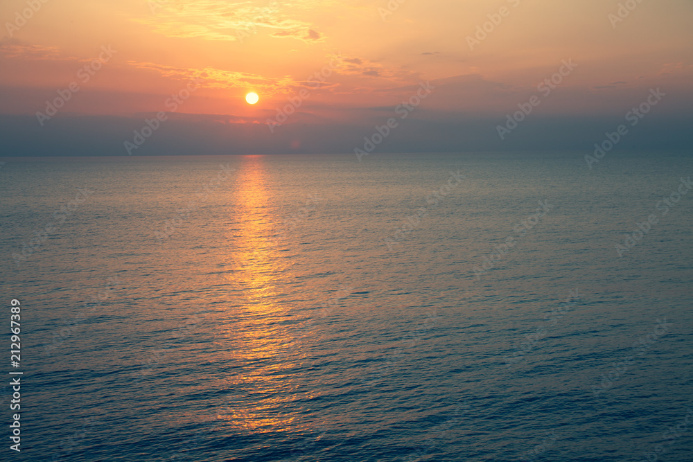 Sunset Sea over the Horizont. Beautiful Ocean Sunshine Landscape, Shimmering Twilight with yellow colors, Warm marine dusk Sun, Reflecting sunlight over the water