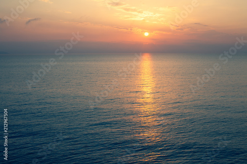 Sunset Sea over the Horizont. Beautiful Ocean Sunshine Landscape  Shimmering Twilight with yellow colors  Warm marine dusk Sun  Reflecting sunlight over the water