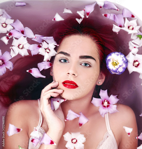 Young woman in bath with flowers relaxaing  photo