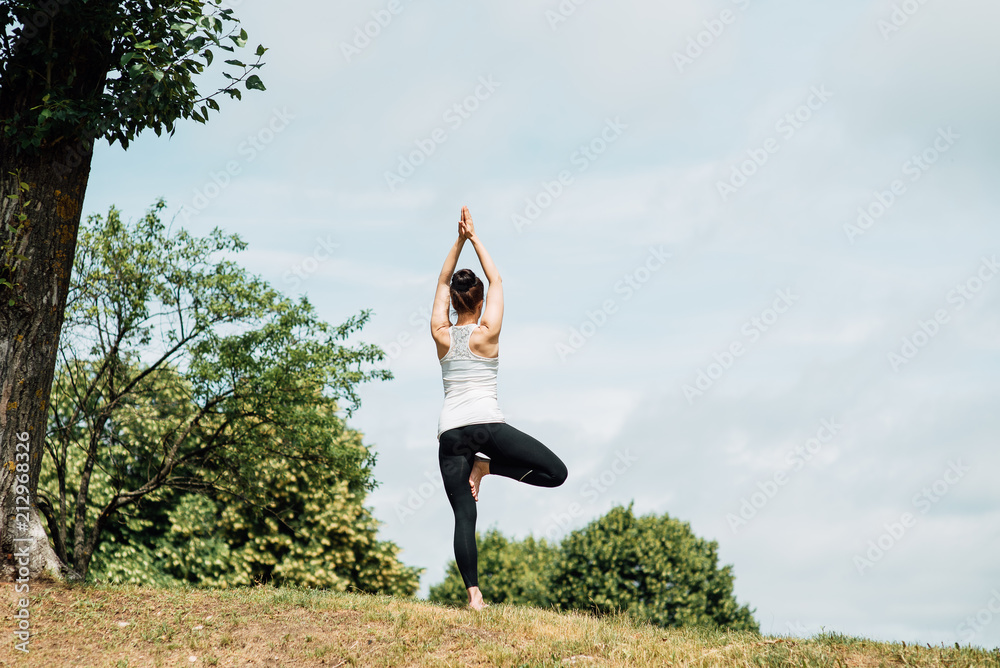 Young girl doing yoga in morning park.Woman Yoga - relax in nature