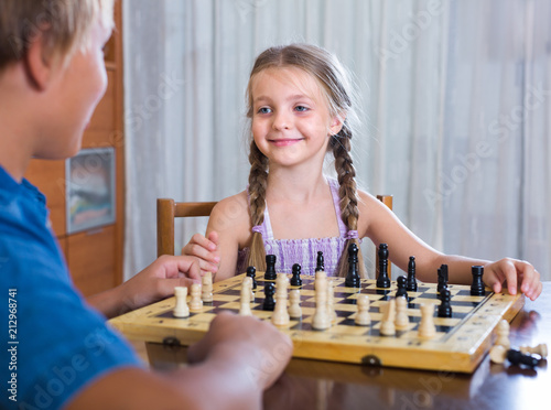 Children playing chess at home.