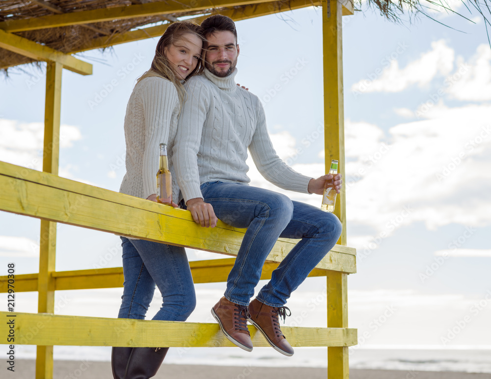 Fototapeta premium young couple drinking beer together at the beach