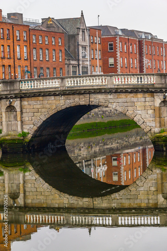 Photography Reflection of buildings and stone bridge in Leffey river