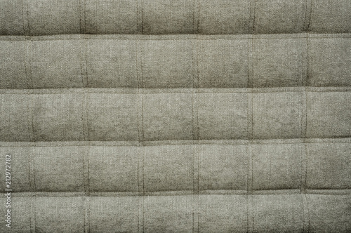 Coach type cloth matting screed tightened with buttons. Natural chesterfield style quilted upholstery backdrop close up. background texture