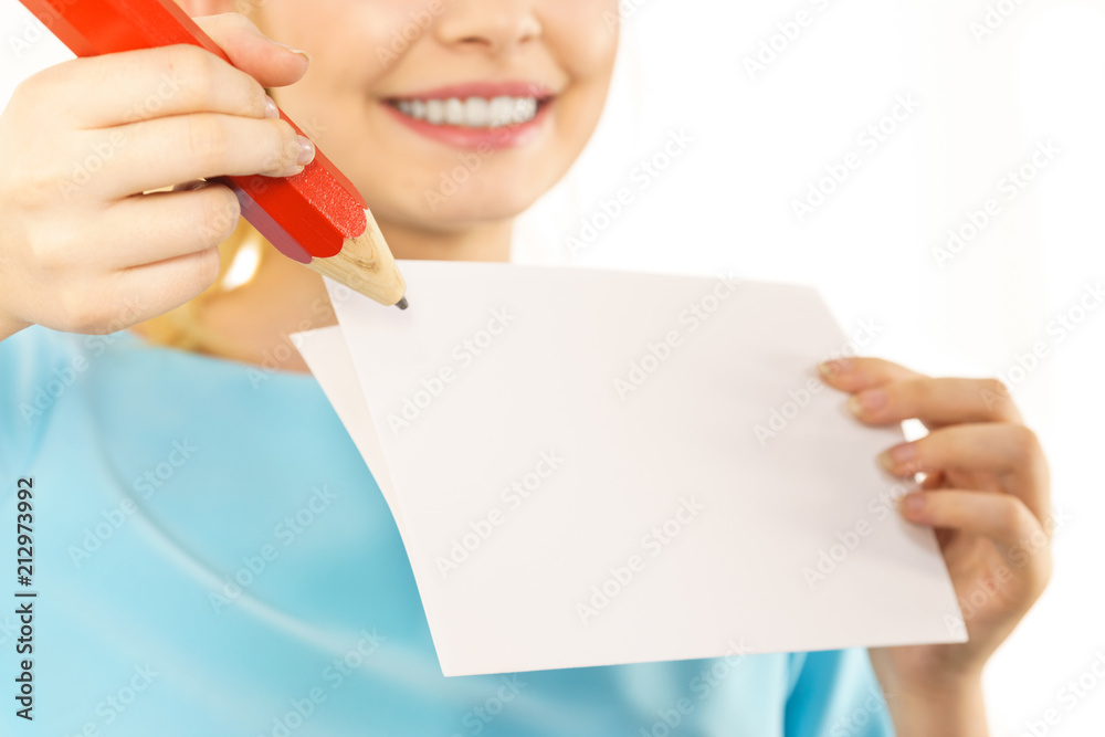 Woman with big pencil writing on paper Woman with big pencil writing on paper