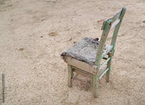 Aged wooden chair with chair pad on ground