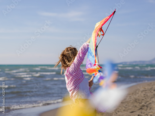 Young Woman holding kite at beach on autumn day