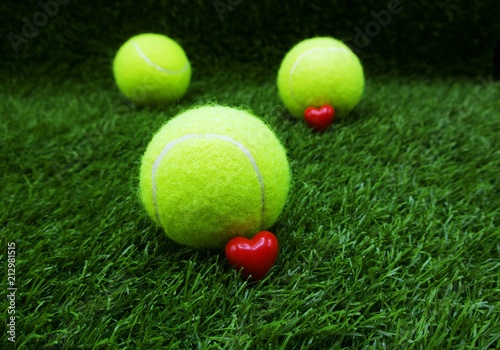 To tennis player with love shape and tennis ball on green grass © thaninee