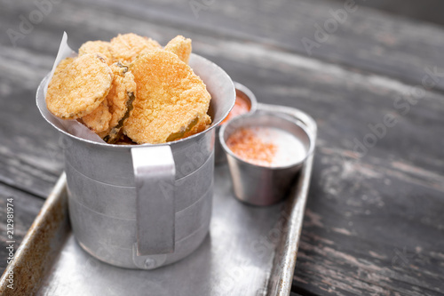 Close up on deep fried pickle slices in an old metal container