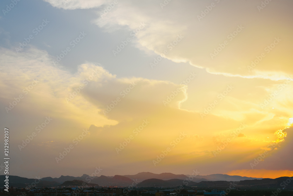 Beautiful sunset with the sun of orange tones behind the mountains and deep blue sky Beautiful sunset with the sun of orange tones behind the mountains and deep blue sky