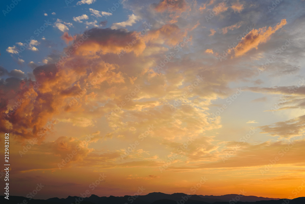 Fototapeta premium Beautiful sunset with the sun of orange tones behind the mountains and deep blue sky