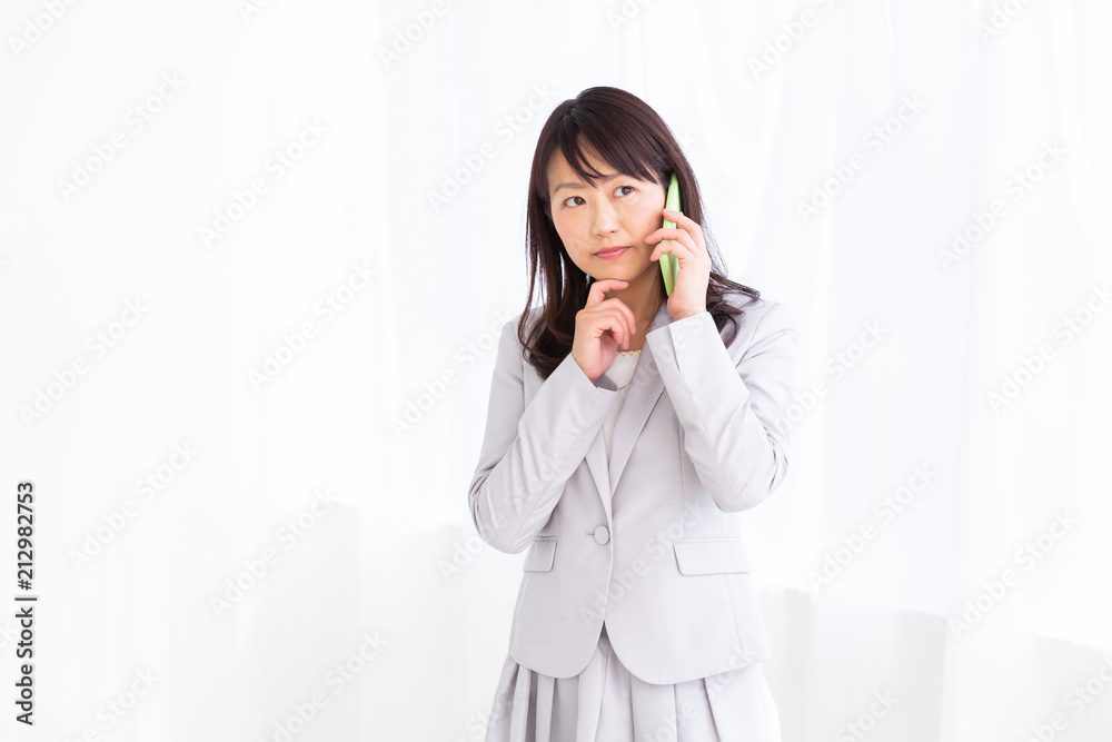 電話をするミドル女性 考える 電話をするミドル女性 考える