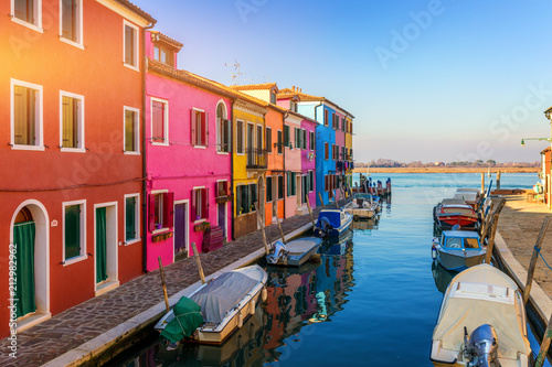 Street with colorful buildings in Burano island, Venice, Italy. Architecture and landmarks of Burano, Venice postcard. Scenic canal and colorful architecture in Burano island near Venice, Italy