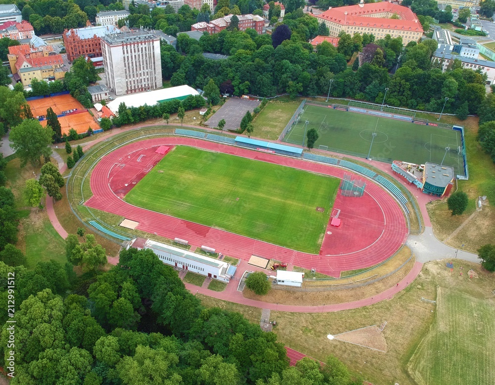 Fototapeta premium City sport center with stadium and court in urban area with park, aerial view
