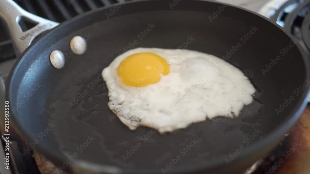 Closeup circling shot of a sunny side up egg frying in a pan Closeup circling shot of a sunny side up egg frying in a pan