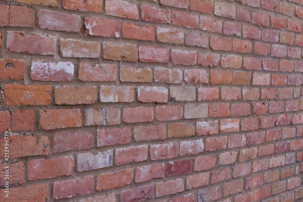 Attractive old weathered traditional clay brick wall in colors of brown, pink, gray, and white