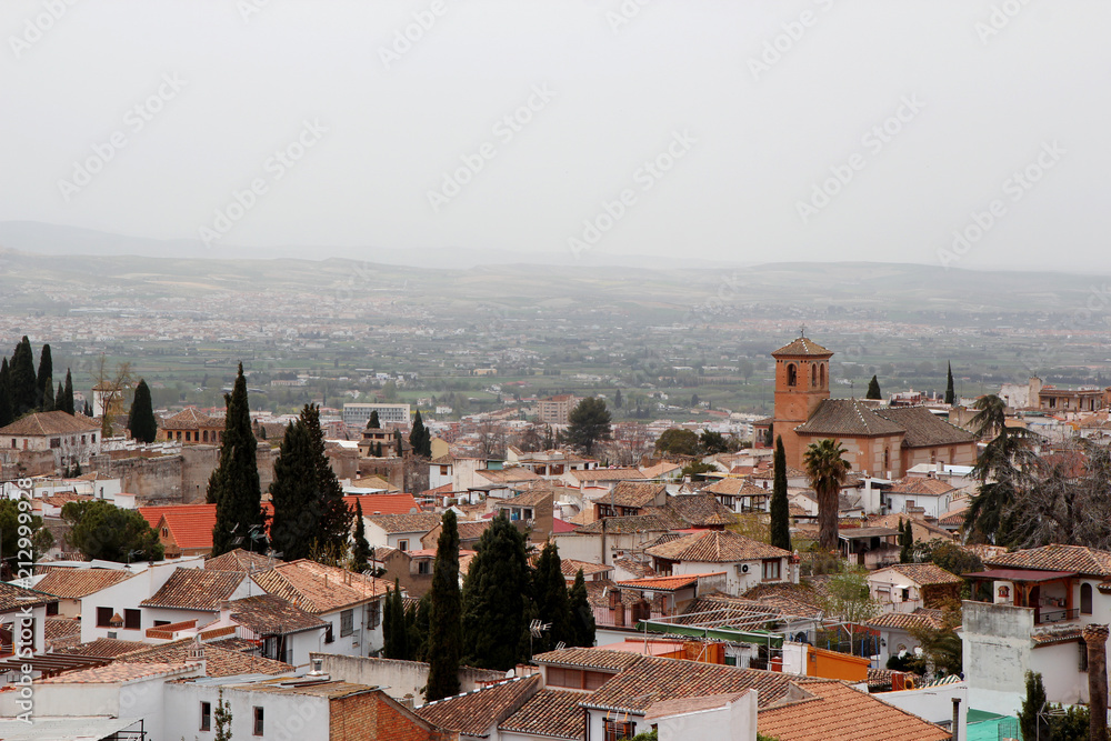 Panoramic view of an ancient town with churches, cathedrals and red roofs, foggy day