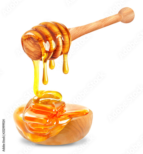 honey dripping into a wooden bowl on a white background