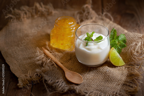 Fotografía Glass of Lemon Yogurt and mint on a brown wooden table