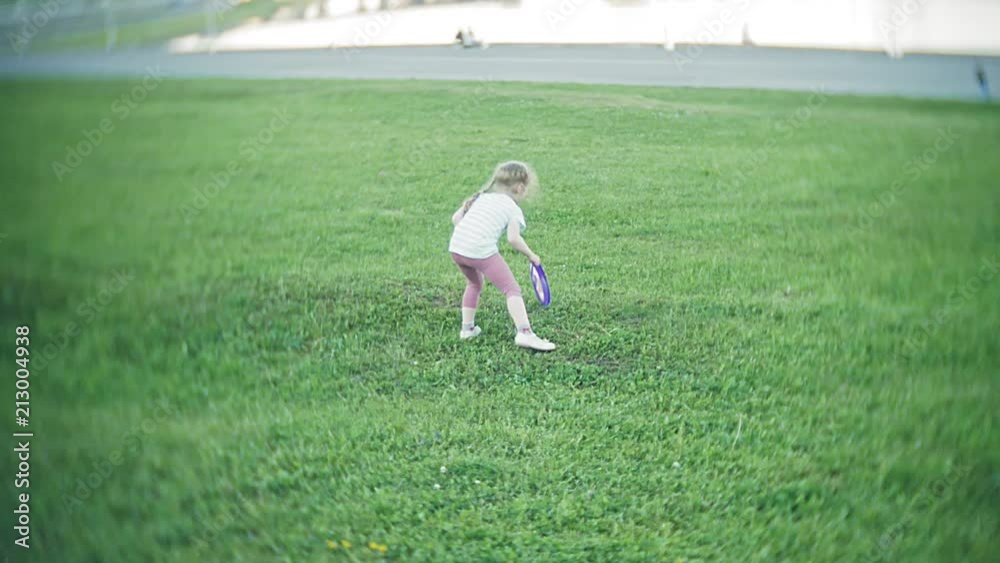 happy woman and daughter playing in frisbee in park happy woman and daughter playing in frisbee in park