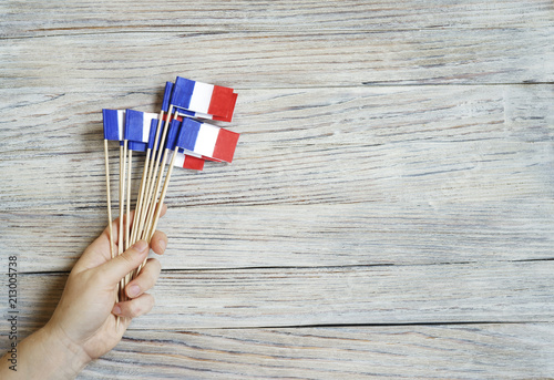 Paper confetti of the national colors of France, white-blue-red on a white wooden background with flags, concept Bastille day, July 14 in France photo