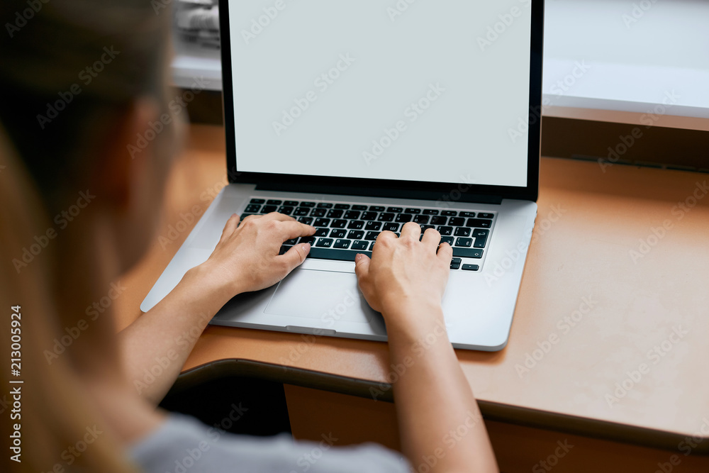 Young women working on her laptop with blank copy space screen for your advertising text message in office, Back view of business woman hands busy using laptop at office desk. Young women working on her laptop with blank copy space screen for your advertising text message in office, Back view of business woman hands busy using laptop at office desk.