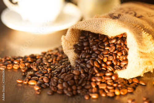 Cup of coffee, bag and scoop on old rusty background