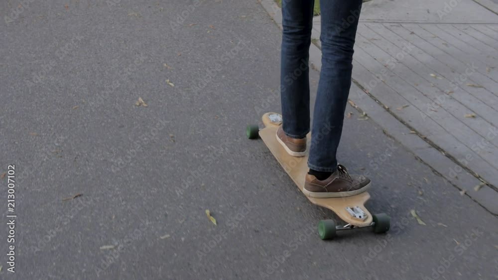 Slow Motion Man Longboarding Along Path By Street Slow Motion Man Longboarding Along Path By Street
