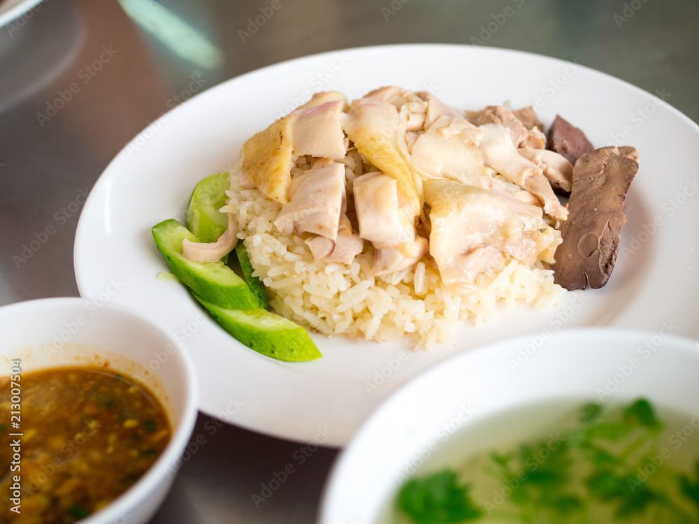 Hainanese chicken rice on a plate with soup Hainanese chicken rice on a plate with soup