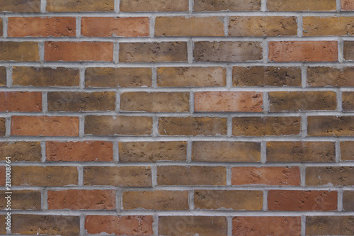 Brick wall background with earth tone color bricks in traditional pattern