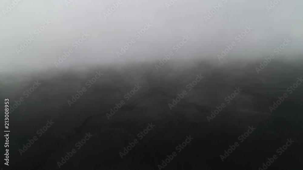 black sand beach covered in clouds from above with drone black sand beach covered in clouds from above with drone
