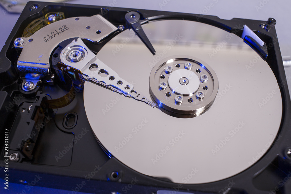 Hard disk drive platter. Open hdd hard disk. Data recovery from damaged media. Disk head above the plates Hard disk drive platter. Open hdd hard disk. Data recovery from damaged media. Disk head above the plates