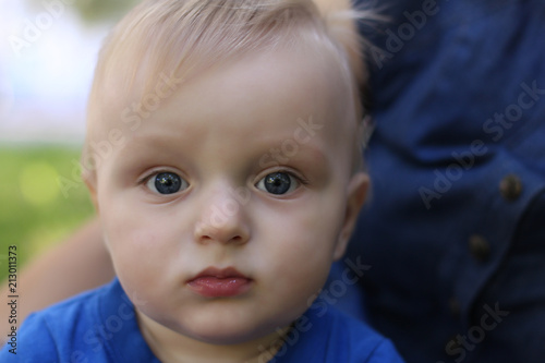 gray-eyed blonde little baby boy in a blue T-shirt  portrait