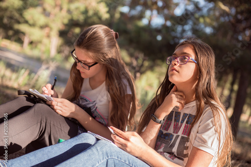 two girls are drawing. Lessons in the open air. Students in extracurricular activities. Two girls are studying, creative activity for teenagers. girl with glasses
 #213011565