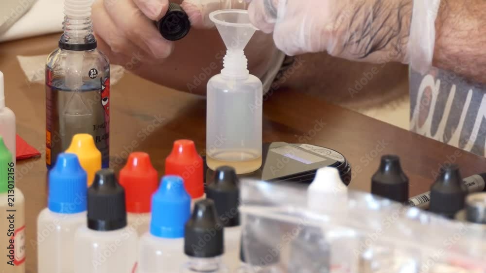 Extreme close up of a man mixing different flavors to create an eliquid for vaping on an electric cigarette. Extreme close up of a man mixing different flavors to create an eliquid for vaping on an electric cigarette.