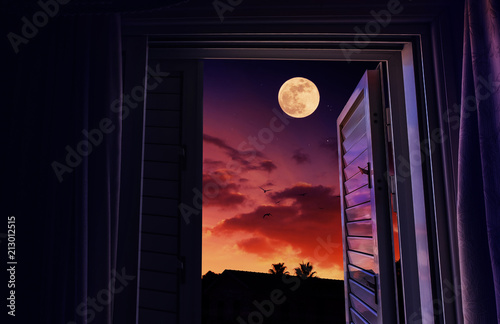 Sunset and moonrise seen from an open window