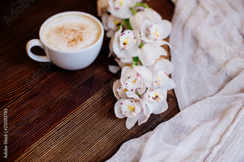 Cup of cappuccino and flowers.