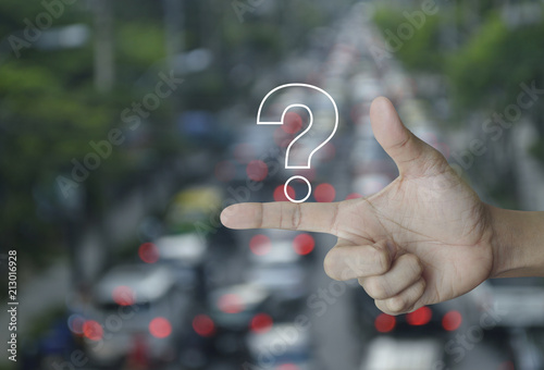 Question mark sign icon on finger over blur of rush hour with cars and road, Customer support concept