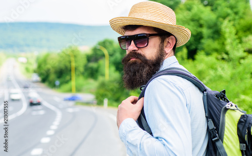 Travel alone. Hitchhiking means transportation gained asking strangers for ride in their car. Hitchhiker travel alone try stop transport to get to destination. Man at edge of highway wait transport