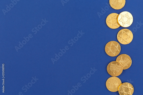Dark blue background with chocolate coins. Hanukkah and judaic holiday concept.
