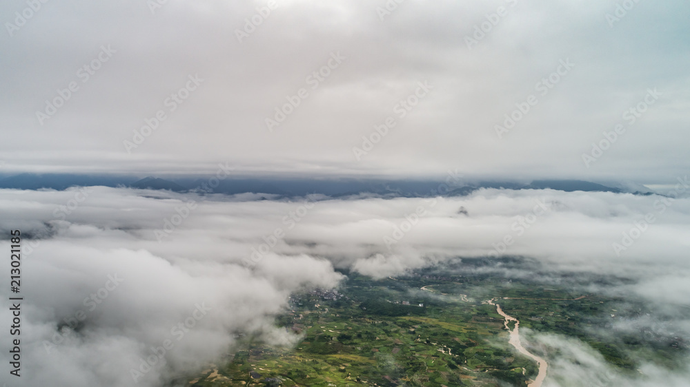 aerial view of cloudscape above village, farmland and roll of hills in morning aerial view of cloudscape above village, farmland and roll of hills in morning