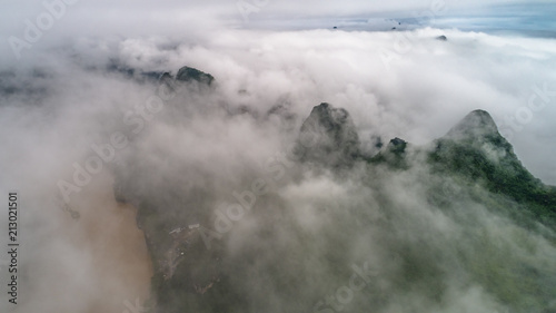 aerial view of cloudscape above village, farmland and roll of hills in morning © Bob