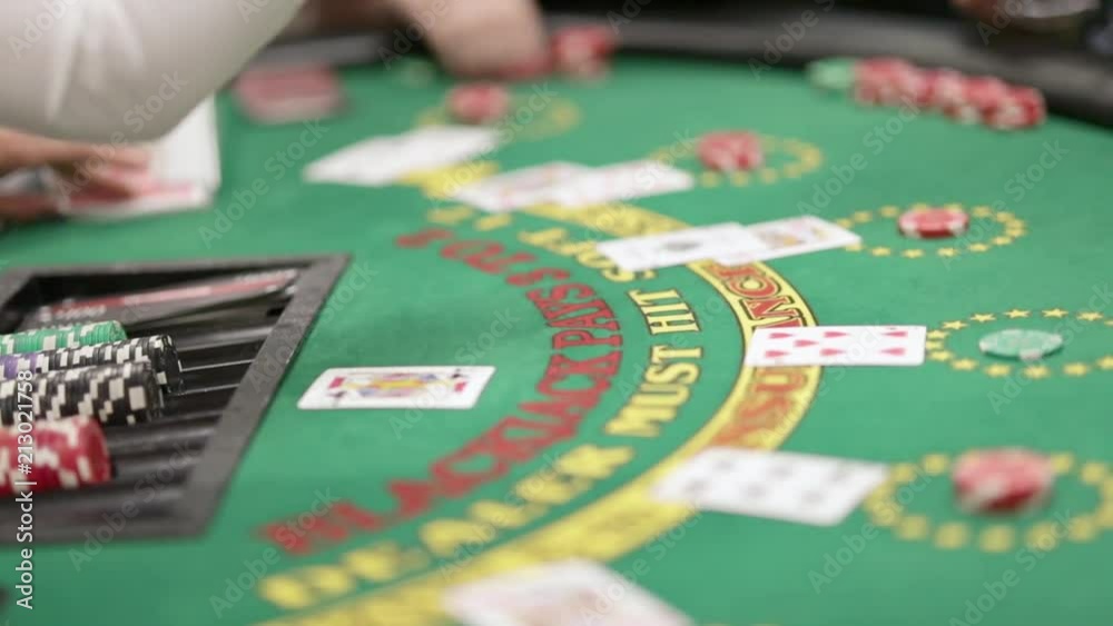 Blackjack game, showing dealer and players' hands, cards being dealt, and chips redistributed Blackjack game, showing dealer and players' hands, cards being dealt, and chips redistributed