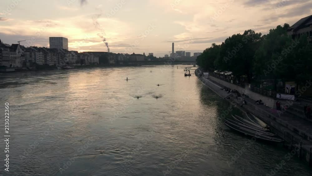 Sunset relaxed mood on either side of the Rhein river in Basel Switzerland . In the background there is a industrial chimney. Sunset relaxed mood on either side of the Rhein river in Basel Switzerland . In the background there is a industrial chimney.